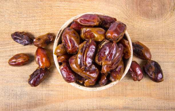 istock Dry dates fruit in the bowl, on the wood background. 927401912