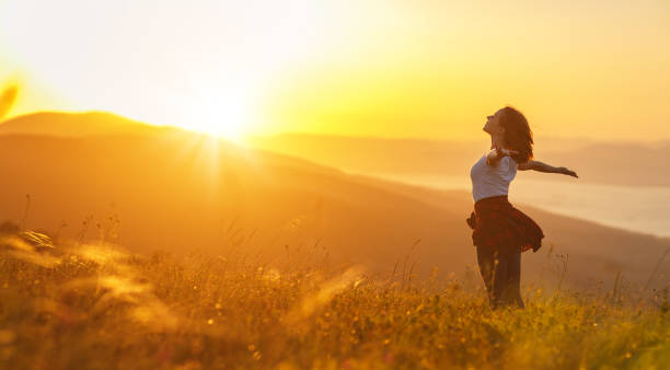 mujer feliz en puesta de sol en naturaleza hasta abrir las manos - people healthy lifestyle freedom happiness fotografías e imágenes de stock