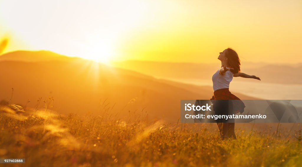 Happy woman   on sunset in nature iwith open hands Happy woman   on the sunset in nature in summer with open hands Women Stock Photo