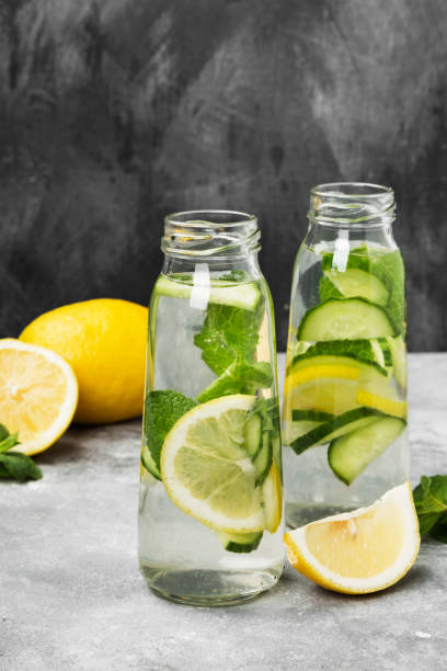 istock Detox drink with cucumber, lemon and mint on a gray background 927407074