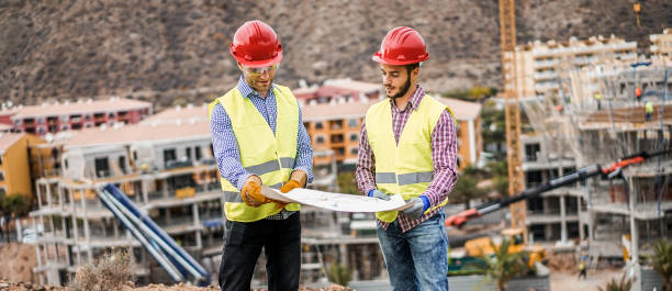 istock Builders on residential construction site looking the building project  - Workers are satisfied of their plan - Dealing, real estate, engineer and industrial concept - Focus on left man face 927407242
