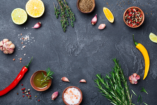 Mixed spices and herbs on black stone table top view. Ingredients for cooking. Food background. Copy space for text.