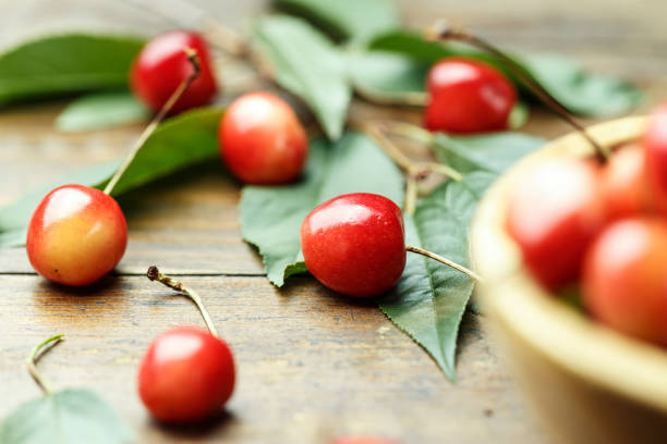 istock Ripe cherries with leaves on a wooden background 927410316