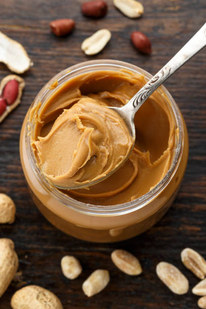 istock peanut butter in an open jar on a brown wooden background 927410682