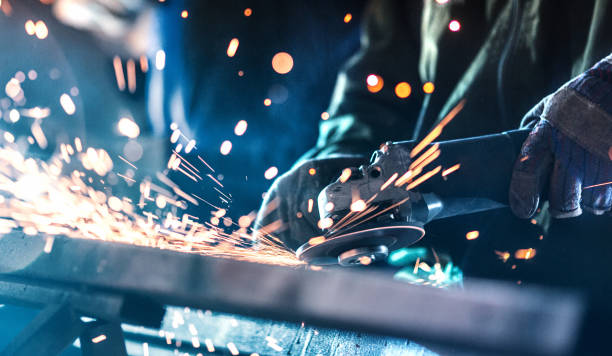 Steel processing plant. Closeup of unrecognizable men grinding steel at a hardware workshop. There are sparks flying in every direction grind stock pictures, royalty-free photos & images