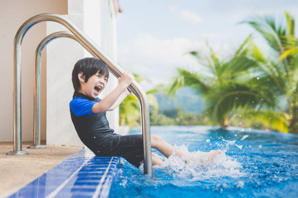 istock child splashing around in the pool 927414076