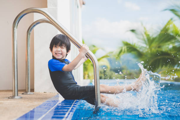 istock child splashing around in the pool 927414078