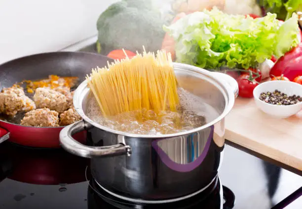 Photo of Cooking spaghetti in a pot with boiling water