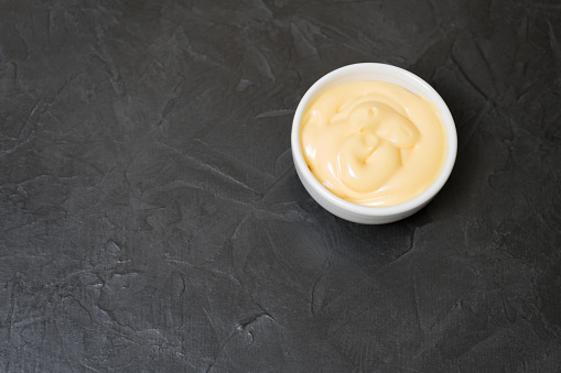Cheese sauce on a black background. Place for your text...