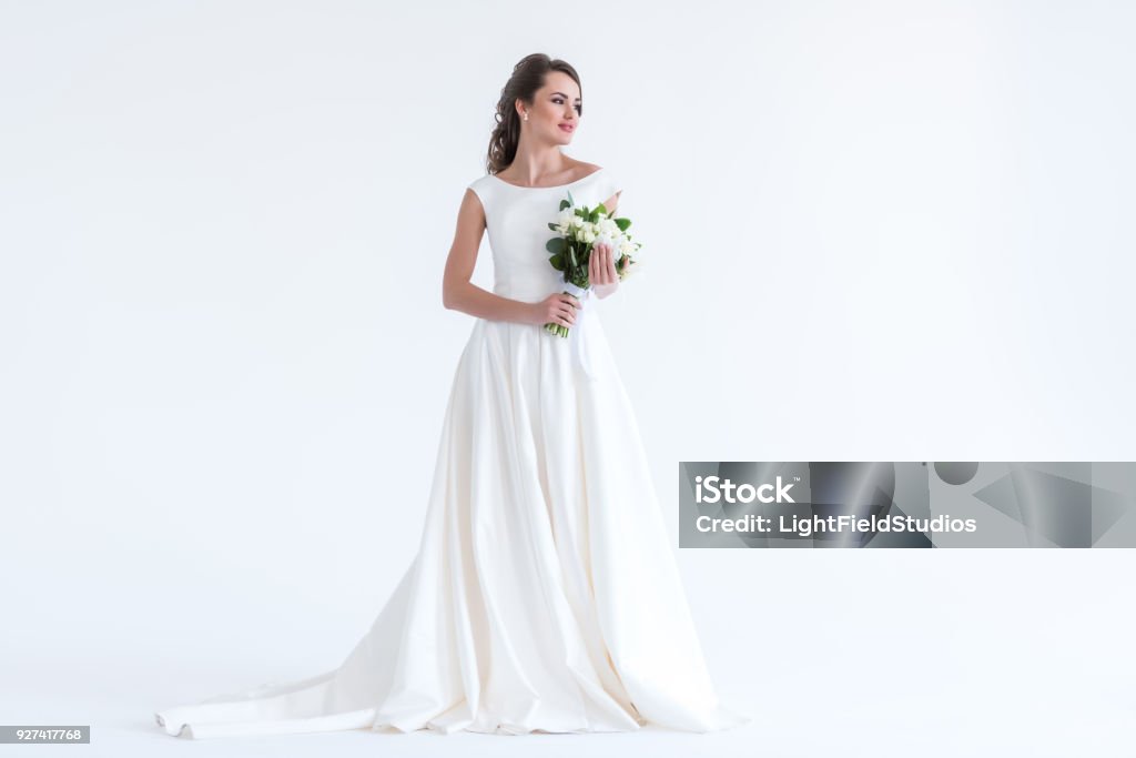 beautiful brunette bride posing in white dress with wedding bouquet, isolated on white Wedding Dress Stock Photo