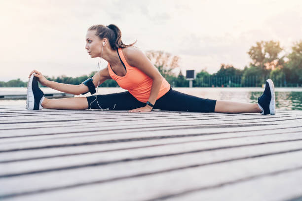 istock Beautiful sportswoman making splits outdoors by the river 927421862