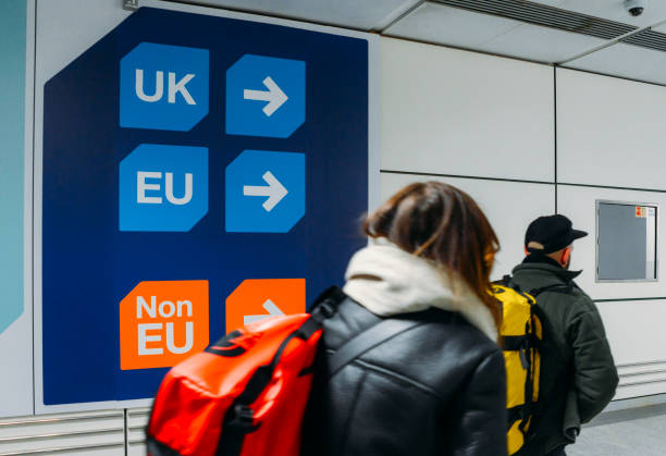 Passengers walks past sign prior to immigration control pass a si stock photo