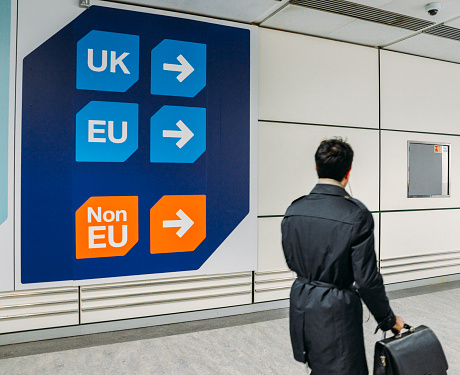 London Gatwick, March 2nd, 2018: Passenger walks past sign prior to immigration control pass a sign pointing towards queues for UK, EU and Non-EU passport holders. In April 2019, UK is set to leave the European Union - Brexit theme