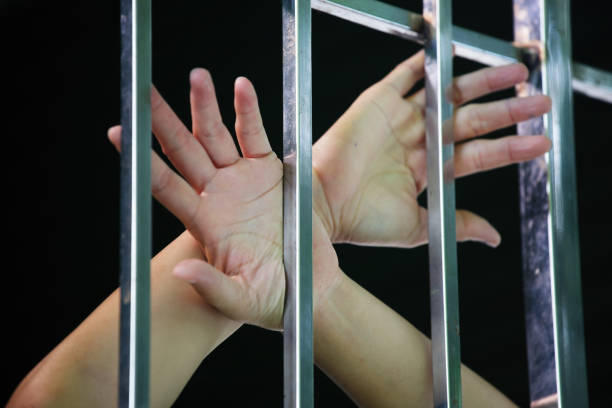 istock hands of prisoner in jail background. 927424112