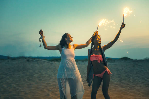 istock Friends celebrating with fireworks on beach at night 927426726