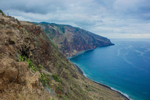 istock Coastline of Madeira with high cliffs along the Atlantic Ocean. blue sky 927436810