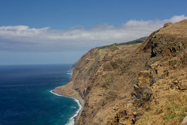 istock Coastline of Madeira with high cliffs along the Atlantic Ocean. blue sky 927436928