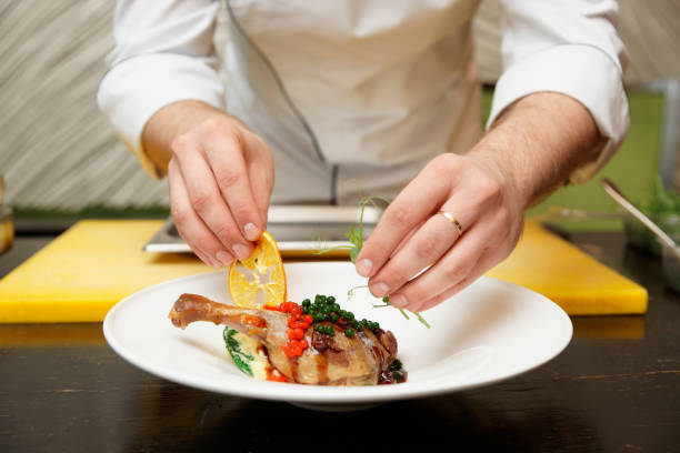 istock Chef is decorating a dish with dried orange and pea sprout 927443312