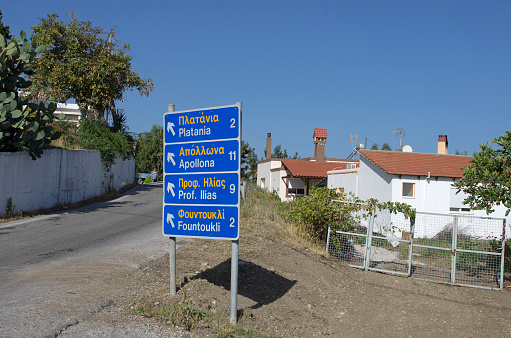 Road sign with names of settlements in the English and Greek languages and the direction of the movement on the island Rhodes (Greece).