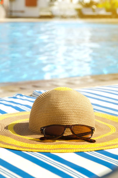 istock Beach accessories at deck chair by the pool. Summer vacation concept. 927448748