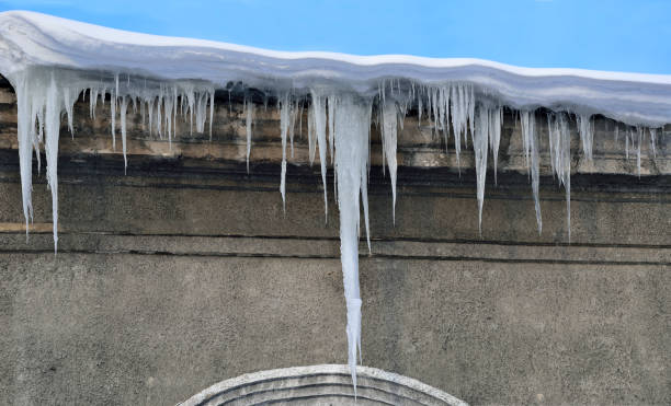 frühling-eiszapfen hängen nach unten vom schnee bedeckten dach - icicle hanging snow moving down stock-fotos und bilder