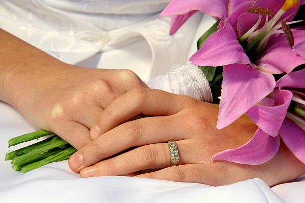 Brides hands holding flowers stock photo