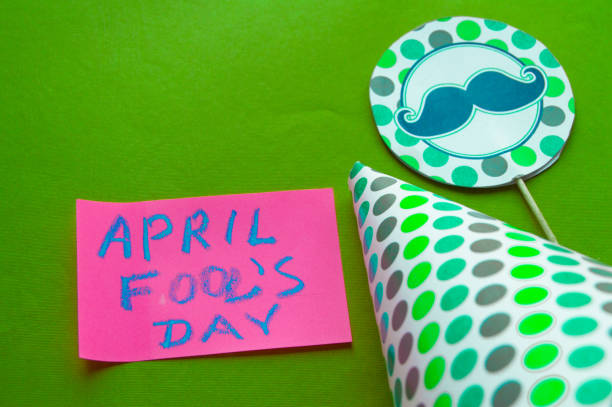 istock Cap, topper with mustache, April fool's day lettering on green background 927455646