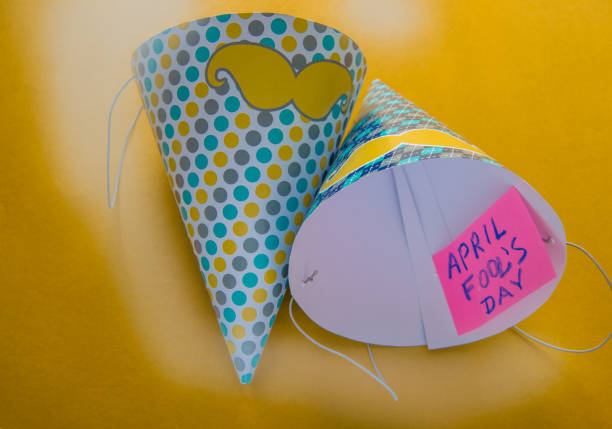 istock Cap, April fool's day lettering, yellow background 927456932