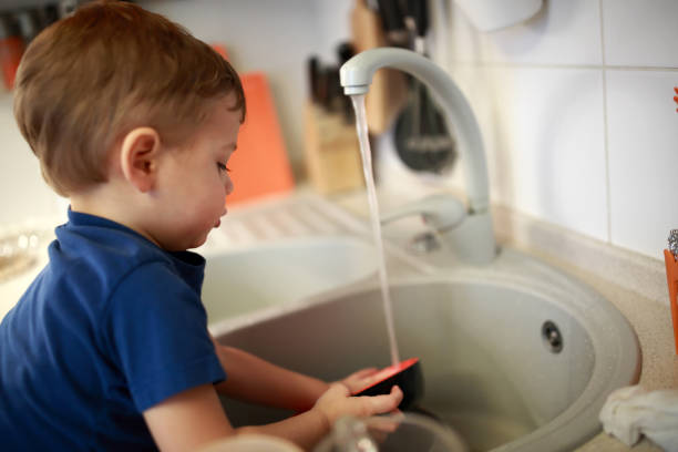 istock Child washing dishes 927461304