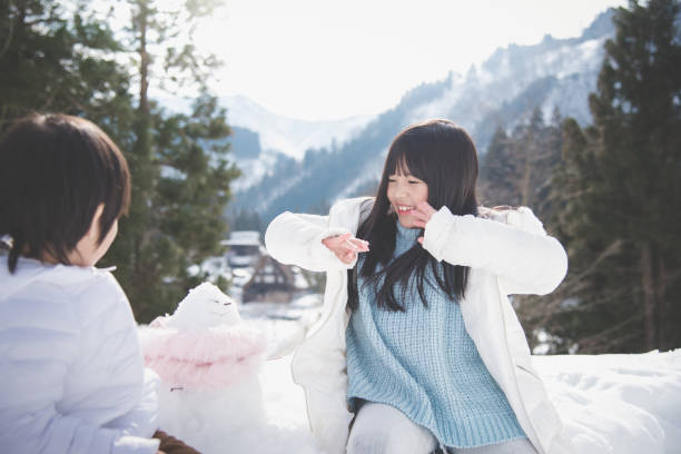 istock Asian children playing with snowman 927464534