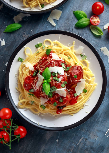 Spaghetti pasta meatballs with tomato sauce, basil, herbs parmesan cheese on dark background Spaghetti pasta meatballs with tomato sauce, basil, herbs parmesan cheese on dark background. spaghetti photos stock pictures, royalty-free photos & images