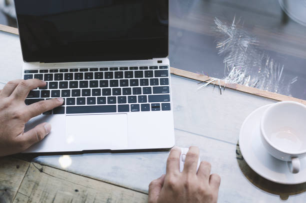 istock attractive hand of business man using laptop working typing on key board with coffee cup in coffee shop. 927473356