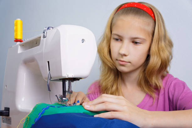 istock Girl learns to sew on an electric sewing machine 927473720