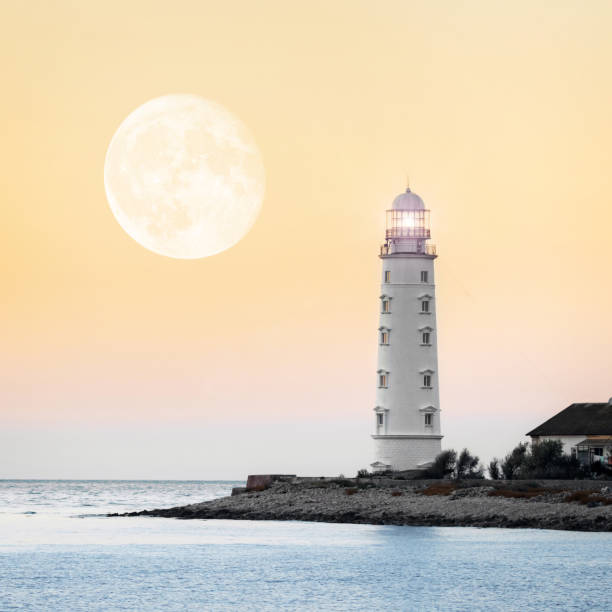 istock Lighthouse searchlight beam near ocean at sunset 927473882
