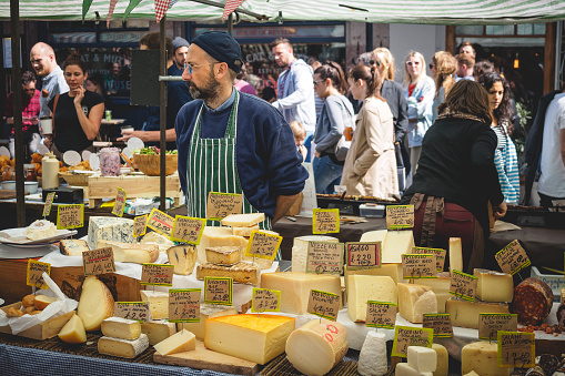 London, UK - March, 2018. Street food stall selling cheese in Broadway Market in Hackney. Landscape format.