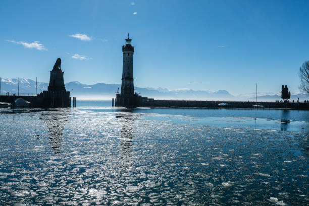 Lindau harbour with ice floes in winter 2018 Ice floes in the Lindau harbour basin around 10:30 in the morning in winter 2018. Lighthouse, lion monument and Austrian Alps in the background with the St. Gallen Rhine Valley. lindau lighthouse stock pictures, royalty-free photos & images