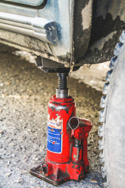 istock A red jack lifts the car to replace the punctured wheel. 927484690