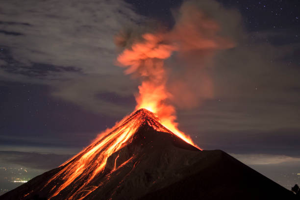 Volcano eruption captured at night, from the Volcano Fuego near Antigua, Guatemala Picture allows to see a lot of clear lava, as well as a few stars and the city lights in the distance. Picture shot around 10:00 PM, on the rim of the Acatenango Volcano which is right next to the volcano Fuego. volcano stock pictures, royalty-free photos & images