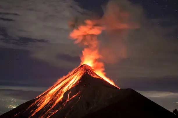 Picture allows to see a lot of clear lava, as well as a few stars and the city lights in the distance. Picture shot around 10:00 PM, on the rim of the Acatenango Volcano which is right next to the volcano Fuego.