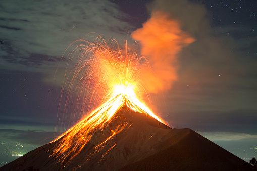 Picture allows to see a lot of clear lava, as well as a few stars and the city lights in the distance. Picture shot around 10:00 PM, on the rim of the Acatenango Volcano which is right next to the volcano Fuego.
