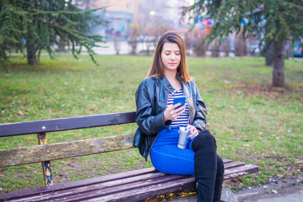 istock Teenage girl using mobile phone in park. 927496292