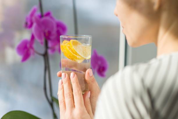 istock Woman drinking water with fresh organic lemon. 927517190