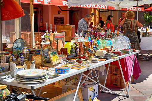 Nice, France - May 13,2013: Market stall at the famous antique market Cours Saleya every Monday in Nice, French Riviera, France. Huge variety of collectibles is on offer: silver, crystal,ceramics, paintings,etc