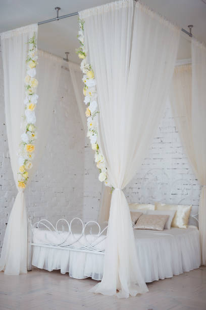 istock Bedroom in soft light colors. Big comfortable elegant double bed in white brick loft interior. 927533584