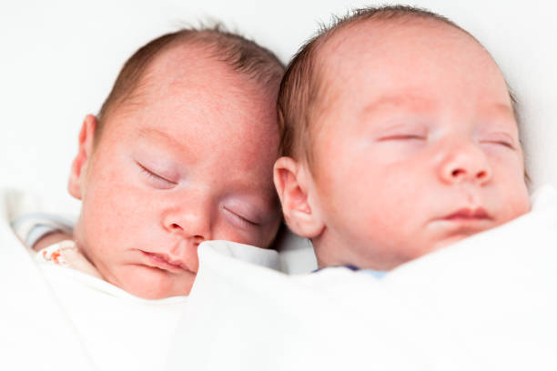 istock Identical twin baby boys sleeping on white 927545500