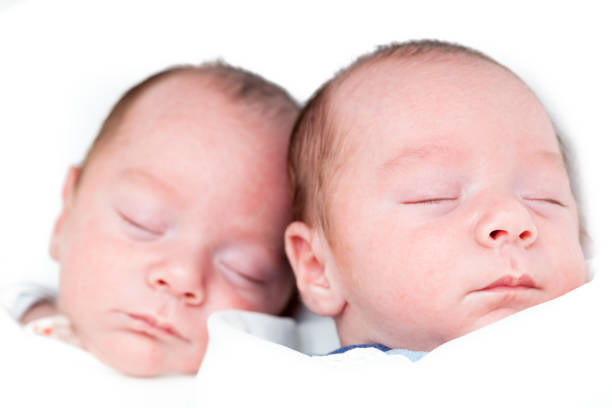 istock Identical twin baby boys sleeping on white 927545548