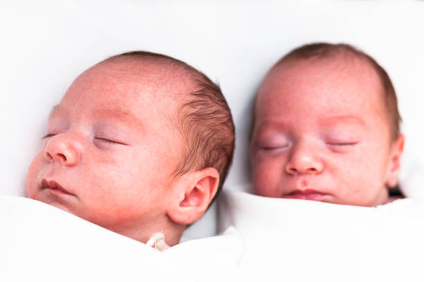 istock Identical twin baby boys sleeping on white 927545576