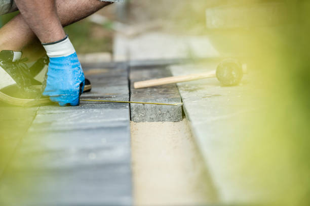 istock Builder measuring a gap for a new paving stone 927548392