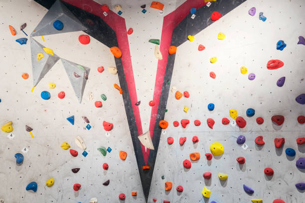 istock Grey wall with climbing holds and ropes in gym. 927556176
