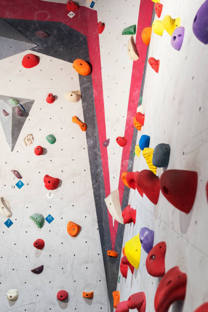 istock Grey wall with climbing holds and ropes in gym. 927556206